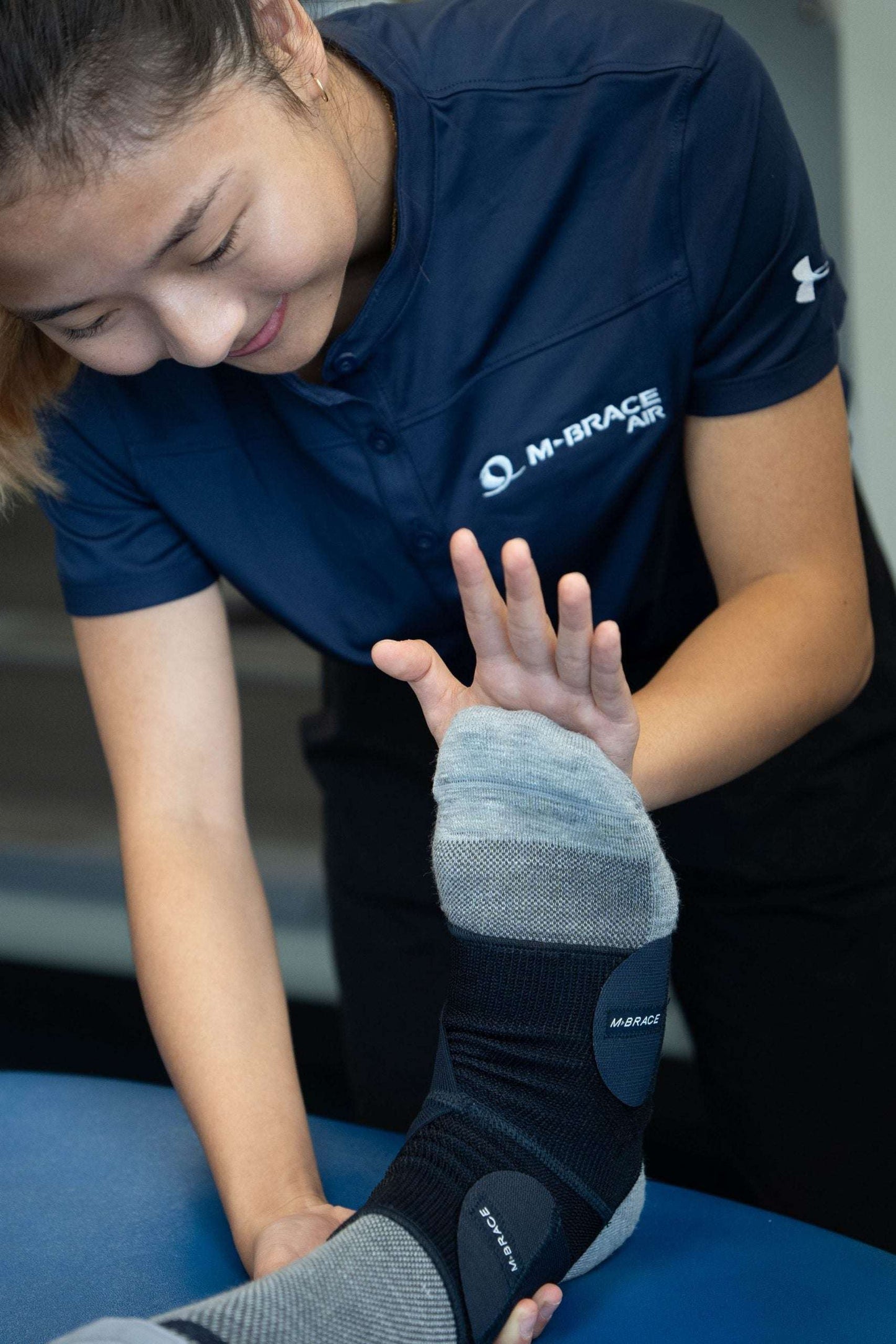 Ankle stabilizer being fitted by a professional, showcasing the M-Brace Strenua Extra Ankle Lock brace.