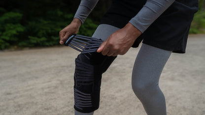 Knee brace being adjusted for joint support and stabilization.